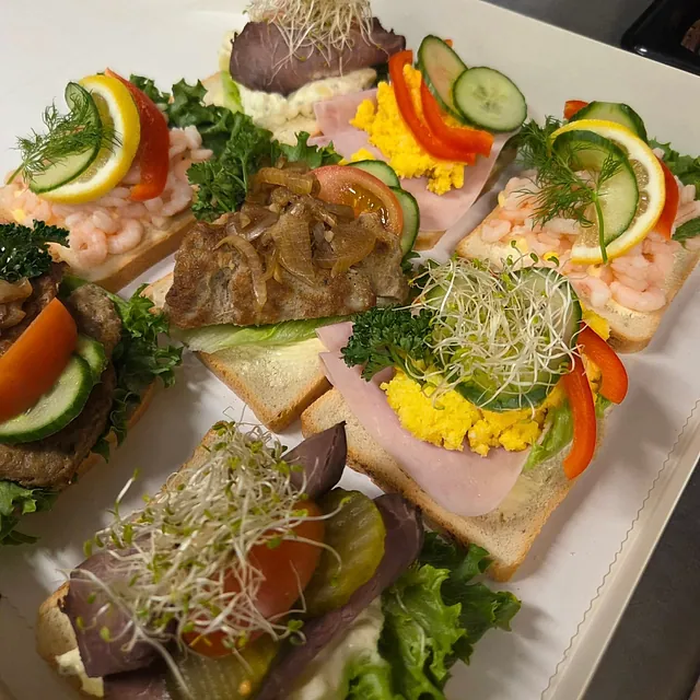 Nærbilde av snitter med karbonade, salat, egg, reker, sitron, spirer, paprika og lignende.