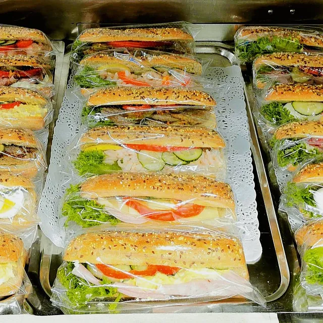 Flere baguetter med salat, egg og skinke etc., dandert på brett.